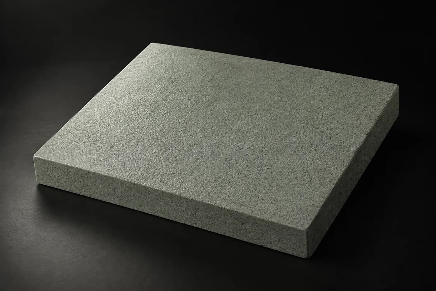 Étude de surface minérale finement grainée sous une lumière rasante.